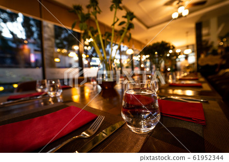 Glass of water on the table with knife and tablecloth inside a restaurant - Restaurant interior with 61952344