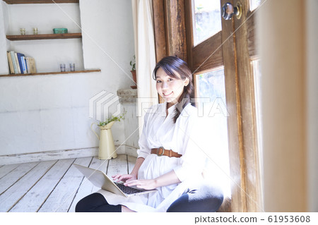 使用個人計算機的婦女在屋子裡 61953608