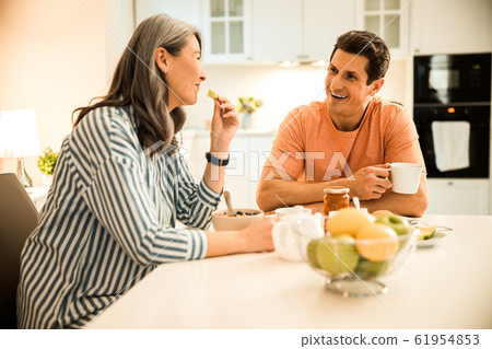 Happy pretty woman looking at man while having breakfast 61954853