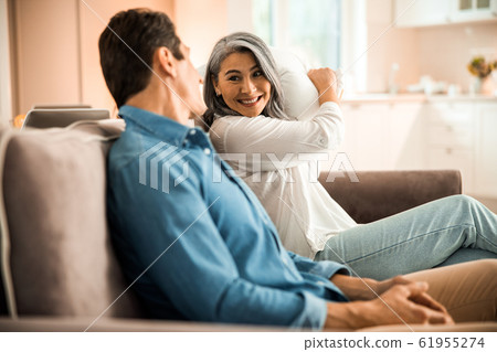 Happy adult woman holding a pillow in hands Happy adult woman holding a pillow in hands 61955274