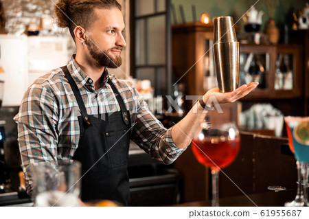 Smiling barman with shaker preparing cocktail at bar Smiling barman with shaker preparing cocktail at bar 61955687