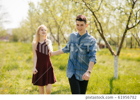 Beautiful couple spend time in a summer park Beautiful couple spend time in a summer park 61956782
