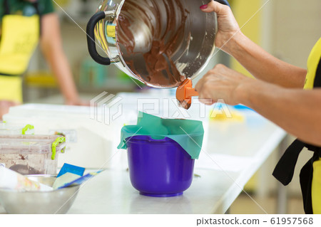 Woman professional pastry chef prepares chocolate Woman professional pastry chef prepares chocolate 61957568