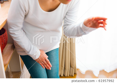 Pregnant woman holding the crotch, water breakage, urine, urine leakage 61957992