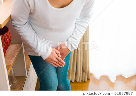 Pregnant woman holding crotch pubic pain rupture urination leaking urine 61957997