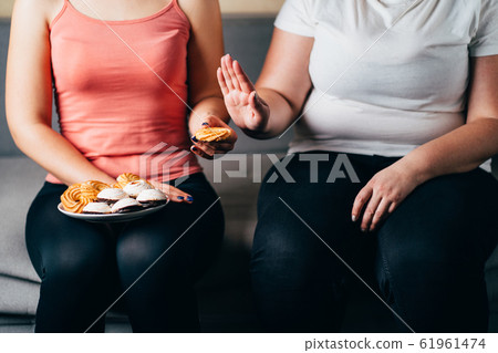 overweight woman refusing junk snacks and sweets 61961474