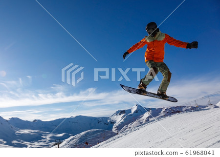 Snowboarder jumps in snow park in the snowy Snowboarder jumps in snow park in the snowy 61968041