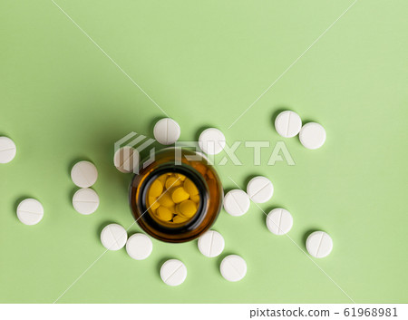 Glass and plastic drug bottles with white pills inside Glass and plastic drug bottles with white pills inside 61968981