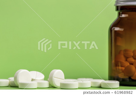 Glass and plastic drug bottles with white pills inside Glass and plastic drug bottles with white pills inside 61968982