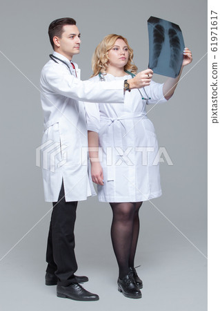 Two young doctors looking at the x-ray picture of lungs 61971617