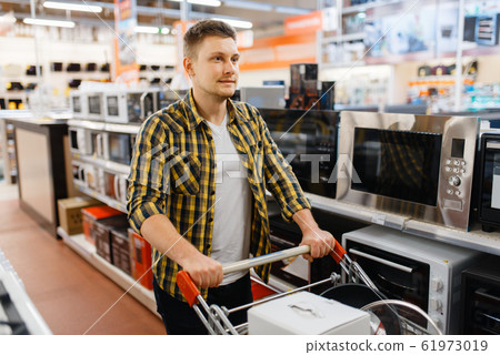 Man choosing microwave in electronics store Man choosing microwave in electronics store 61973019