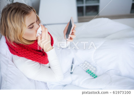 Sick woman suffers from a cold at home Sick woman suffers from a cold at home 61973100
