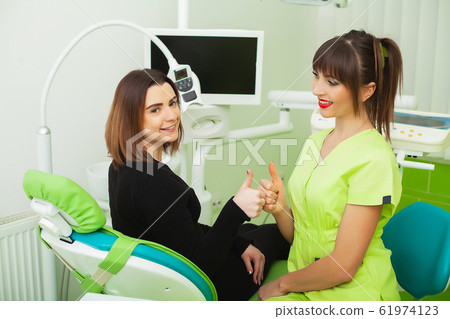 The dentist are treating teeth to client in dental office The dentist are treating teeth to client in dental office 61974123