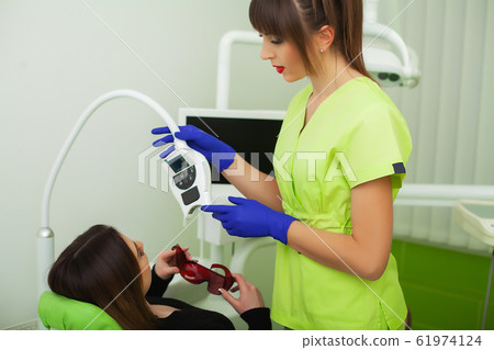 The dentist are treating teeth to client in dental office The dentist are treating teeth to client in dental office 61974124