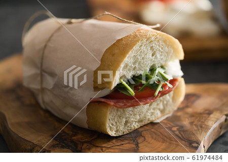 ciabatta sandwich with salami and mozzarella cheese on walnut table ciabatta sandwich with salami and mozzarella cheese on walnut table 61974484
