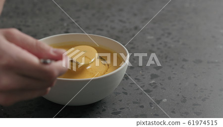 man eating pumpkin cream soup in white bowl on terrazzo countertop man eating pumpkin cream soup in white bowl on terrazzo countertop 61974515