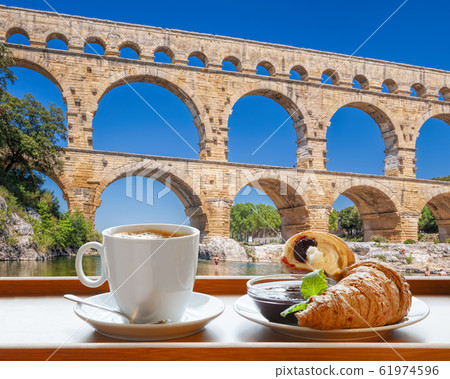 Coffee with croissants against Pont du Gard, is an old Roman aqueduct in Provence, France Coffee with croissants against Pont du Gard, is an old Roman aqueduct in Provence, France 61974596