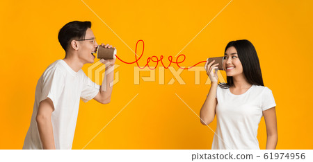 Asian couple sharing feelings through can phone 61974956