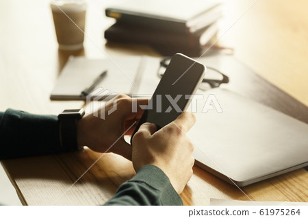 Unrecognizable Man Texting On Cellphone Sitting At Workplace Indoor Unrecognizable Man Texting On Cellphone Sitting At Workplace Indoor 61975264