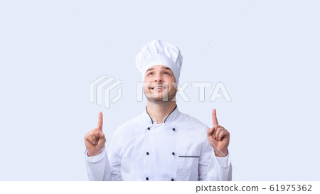 Chef Guy Pointing Fingers Upward Standing Over White Background, Panorama Chef Guy Pointing Fingers Upward Standing Over White Background, Panorama 61975362