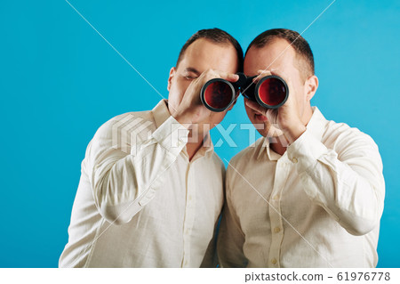 Twins Looking Through Binoculars Twins Looking Through Binoculars 61976778