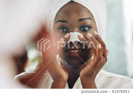 Woman Applying Nose Pore Strip Woman Applying Nose Pore Strip 61976951