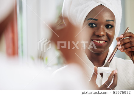 African Woman Applying Make Up African Woman Applying Make Up 61976952