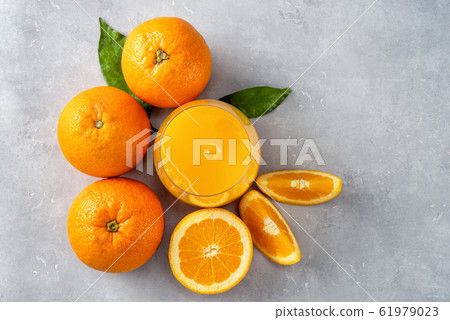 Top view of fresh orange juice, oranges and slices on blue background Top view of fresh orange juice, oranges and slices on blue background 61979023