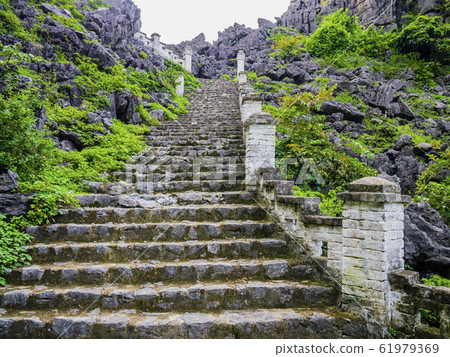 Stone staircase ascending the lying dragon mountain to reach the Hang Mua pagoda, one of the most beautifiul viewpoint in Ninh Binh, Vietnam Stone staircase ascending the lying dragon mountain to reach the Hang Mua pagoda, one of the most beautifiul viewpoint in Ninh Binh, Vietnam 61979369