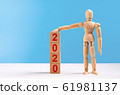 Wooden mannequin figure raise a hand and put on tower of cubes with red inscription 2020 year 61981137