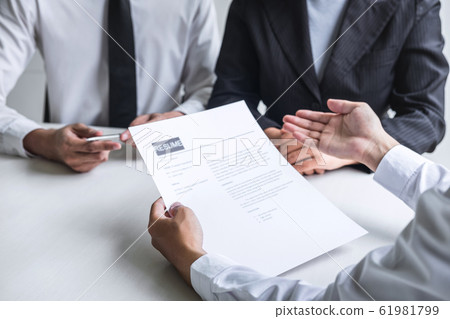 Employer or committee holding reading a resume Employer or committee holding reading a resume 61981799