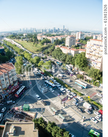 Istanbul city view from high up-cars and pedestrians crossing the road, houses with brown roofs visible in the distance and high-rise buildings Istanbul city view from high up-cars and pedestrians crossing the road, houses with brown roofs visible in the distance and high-rise buildings 61981926