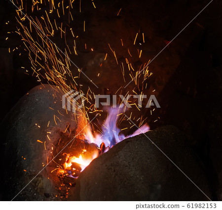 Smithy fire flame tips with sparks closeup Smithy fire flame tips with sparks closeup 61982153