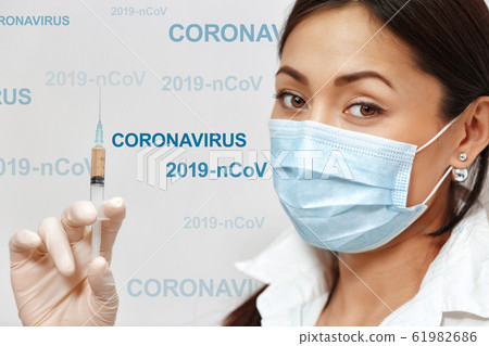 doctor woman holding a syringe with an injection for the disease doctor woman holding a syringe with an injection for the disease 61982686