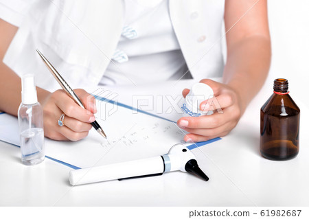 doctor writes a prescription for the patient 61982687
