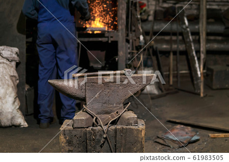 the hammer lies on the anvil in the forge while 61983505