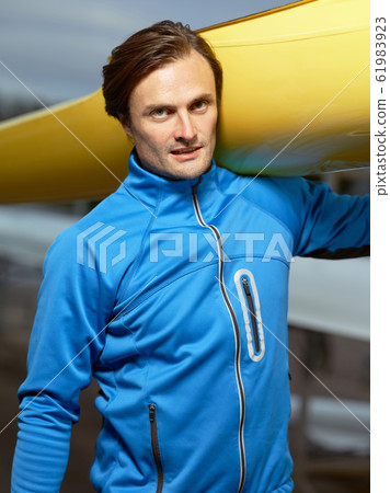 Portrait of athletic man with boat 61983923