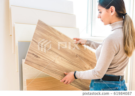 home repair. portrait of woman choosing wood laminated flooring in shop home repair. portrait of woman choosing wood laminated flooring in shop 61984087