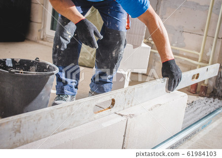 Mason plastering the concrete to build wall, 61984103