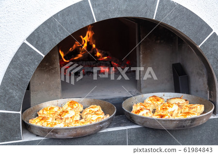 Oven with burning firewood for cooking pies Oven with burning firewood for cooking pies 61984843