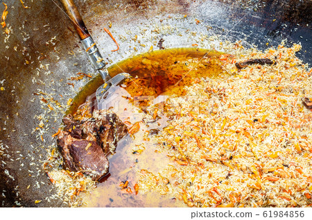 Appetizing traditional Uzbek pilaf in a large Appetizing traditional Uzbek pilaf in a large 61984856