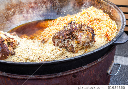 Appetizing traditional Uzbek pilaf in a large Appetizing traditional Uzbek pilaf in a large 61984860