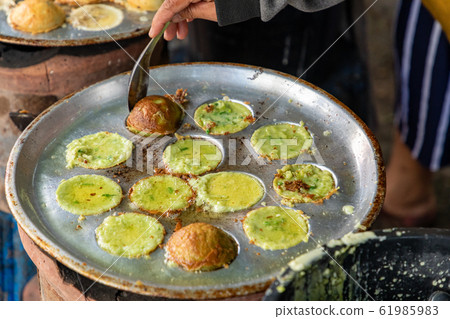 Making fresh coconut pancakes. 61985983