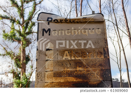Burnt sign on the road after a forest fire in Monchique, Portugal. Portimao, Monchique, Alcaria do Peso, village name, weight. 61989060