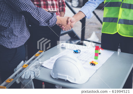 engineers and businessman shaking hands for make an agreement in investment about construction project. success dealing greeting and partner concept. engineers and businessman shaking hands for make an agreement in investment about construction project. success dealing greeting and partner concept. 61994521