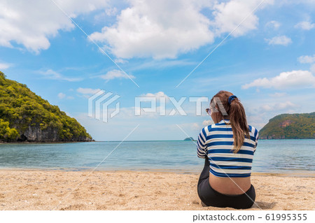 Back side view of Asian woman sitting on tropical Back side view of Asian woman sitting on tropical 61995355
