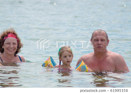 Grandparents And Granddaughter swimming in the Grandparents And Granddaughter swimming in the 61995358