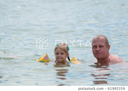 Grandparents And Granddaughter swimming in the Grandparents And Granddaughter swimming in the 61995359