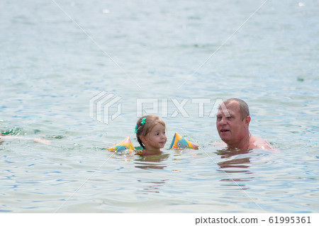 Grandparents And Granddaughter swimming in the Grandparents And Granddaughter swimming in the 61995361