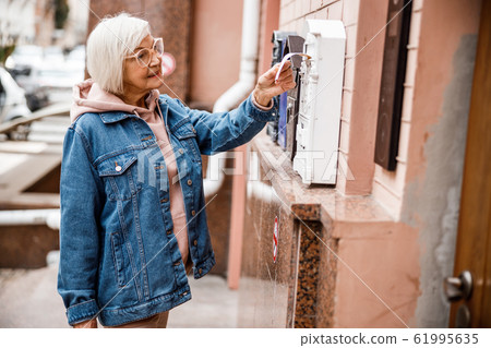 Mature female using mailbox outdoors stock photo 61995635